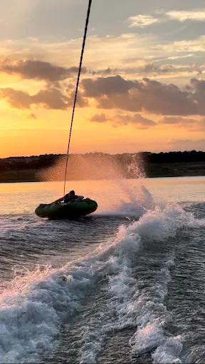 Tubing behind the boat at sunset on Lake Travis